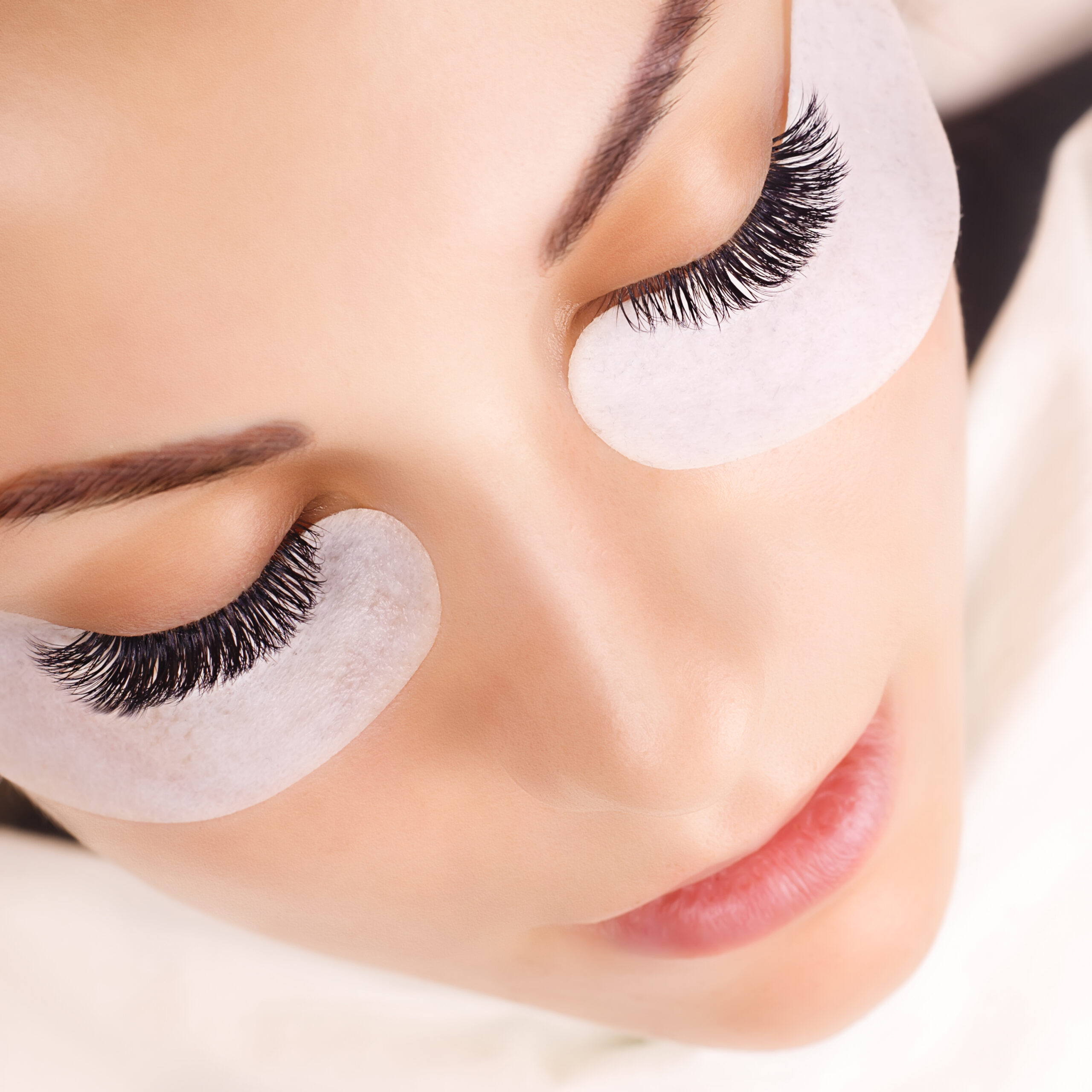 Eyelash Extension Procedure. Woman Eye with Long Eyelashes. Close up, selective focus.